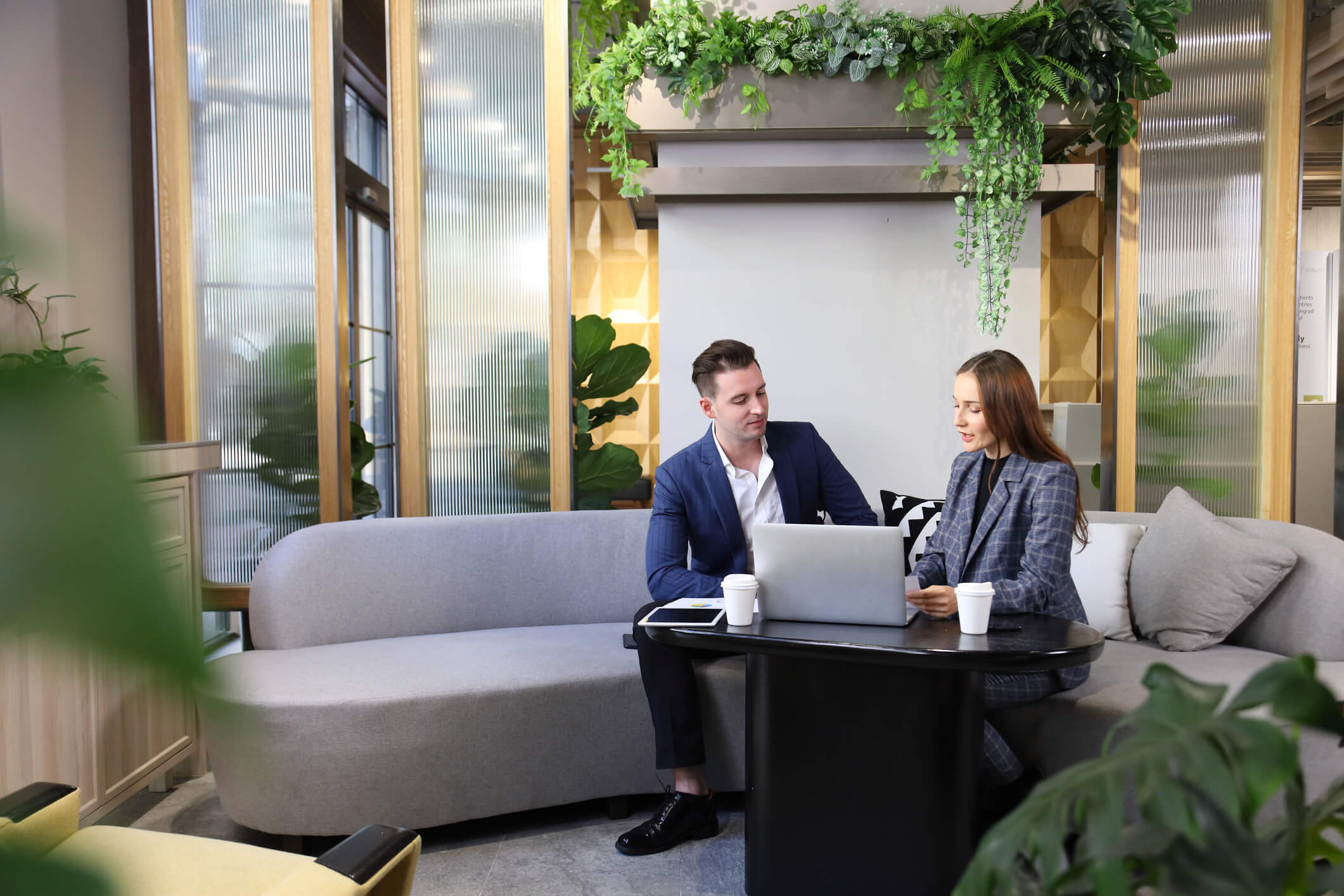 Caucasian business people is working on new strategic planning for next year while working in green eco friendly modern working space surrounded by air purifying house plant