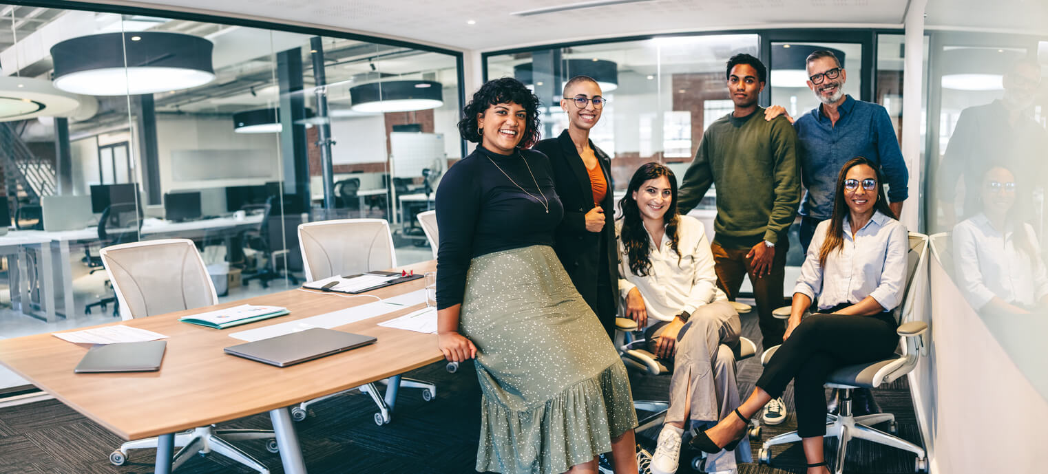 The IAdea team gathered around a meeting table in an open-plan office