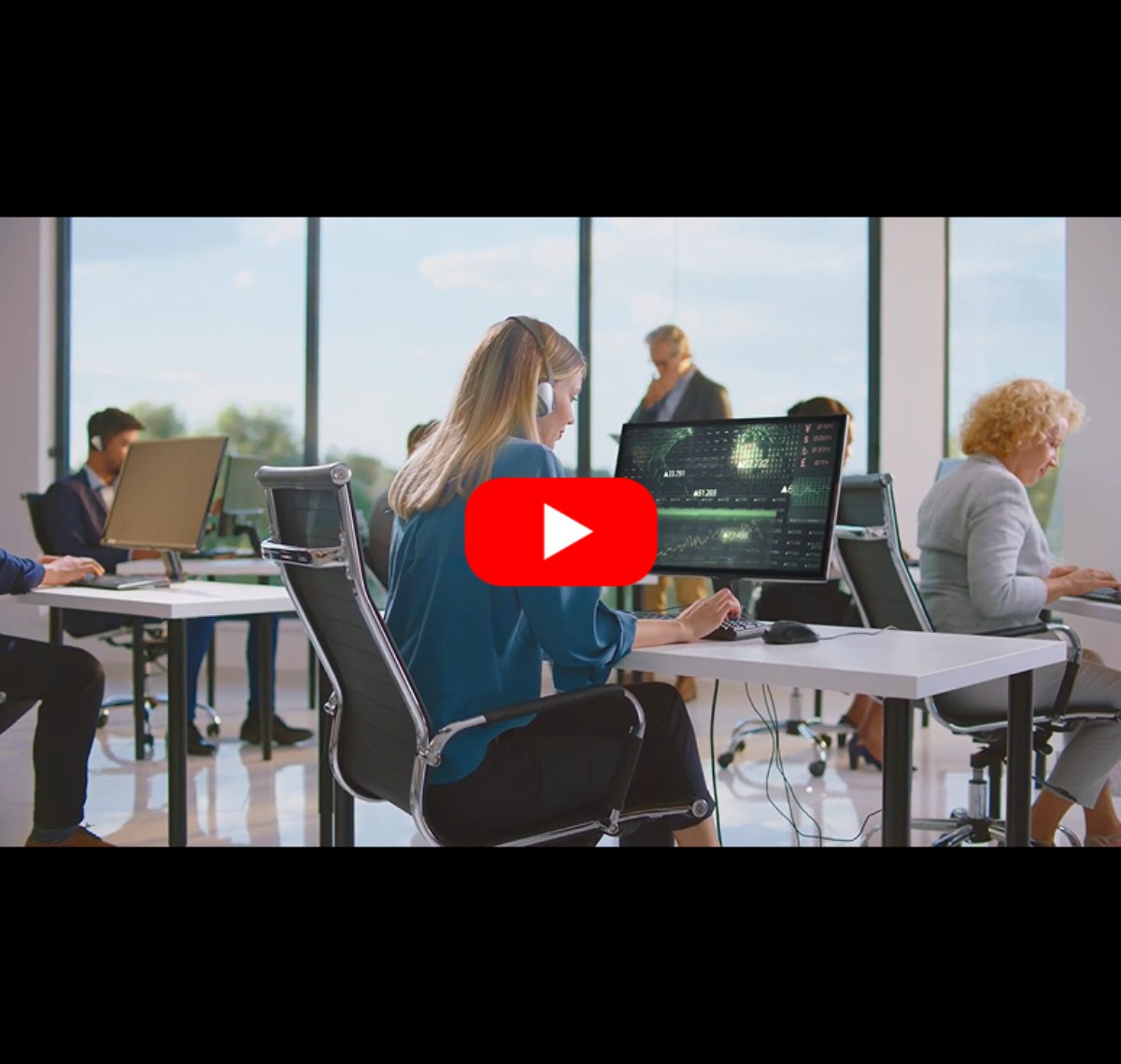 Employees working at desks in a modern office with IAdea desk booking workflow