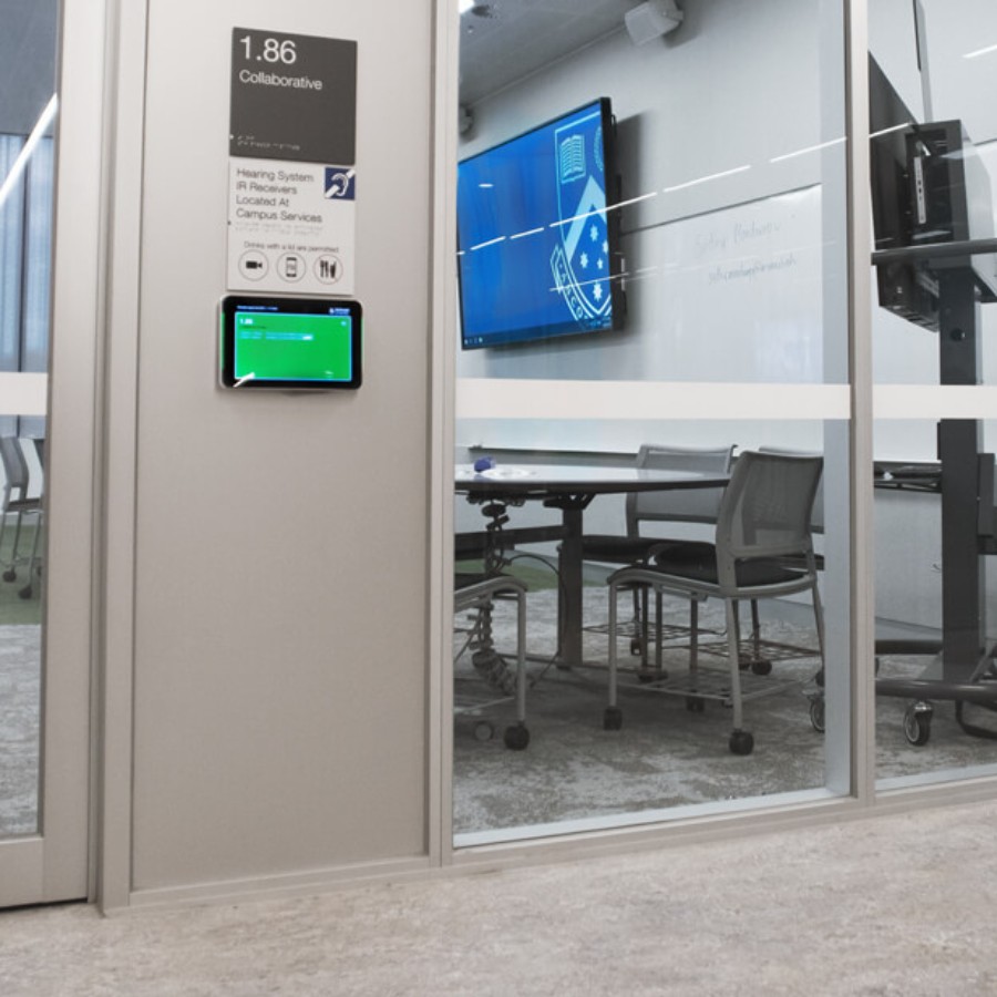 Modern meeting room interior in an educational setting with IAdea room scheduling display