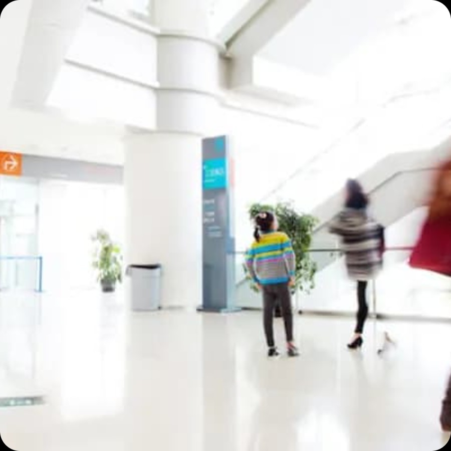 Hospital corridor with digital information screens and IAdea wayfinding kiosks for patient navigation