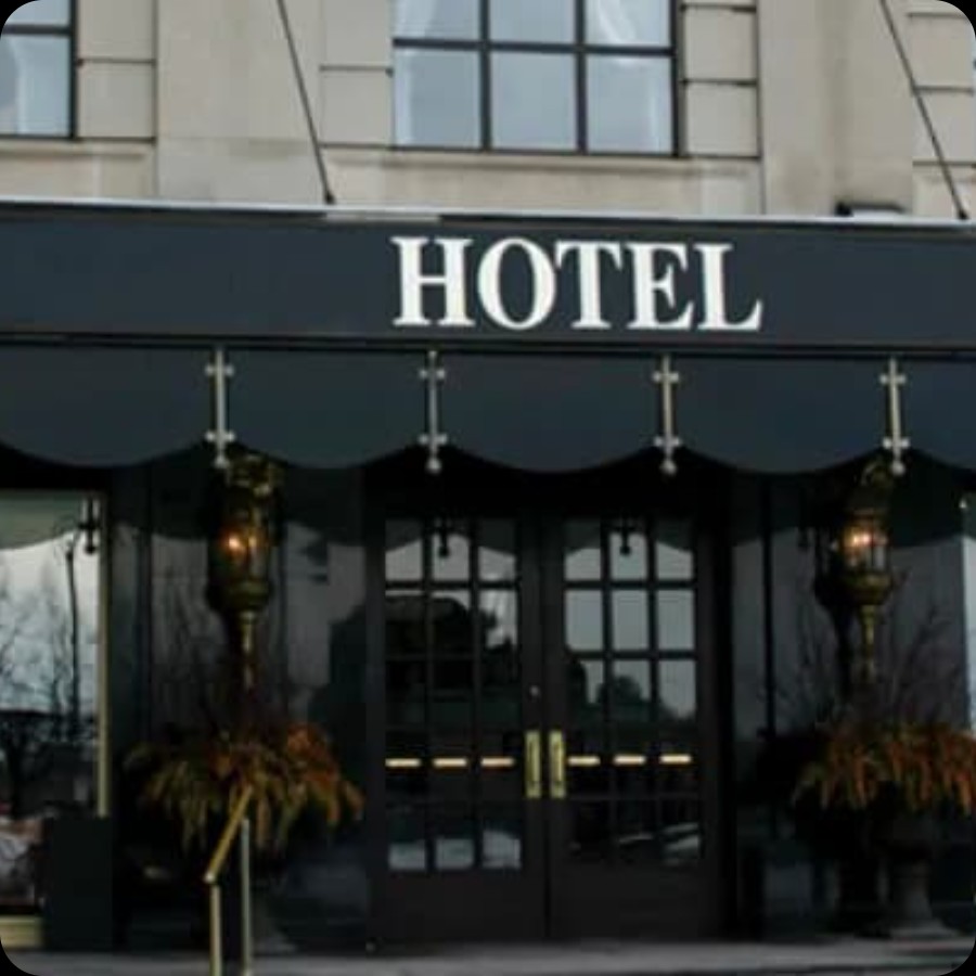 Hotel entrance with black awning and exterior signage area for IAdea hospitality digital displays