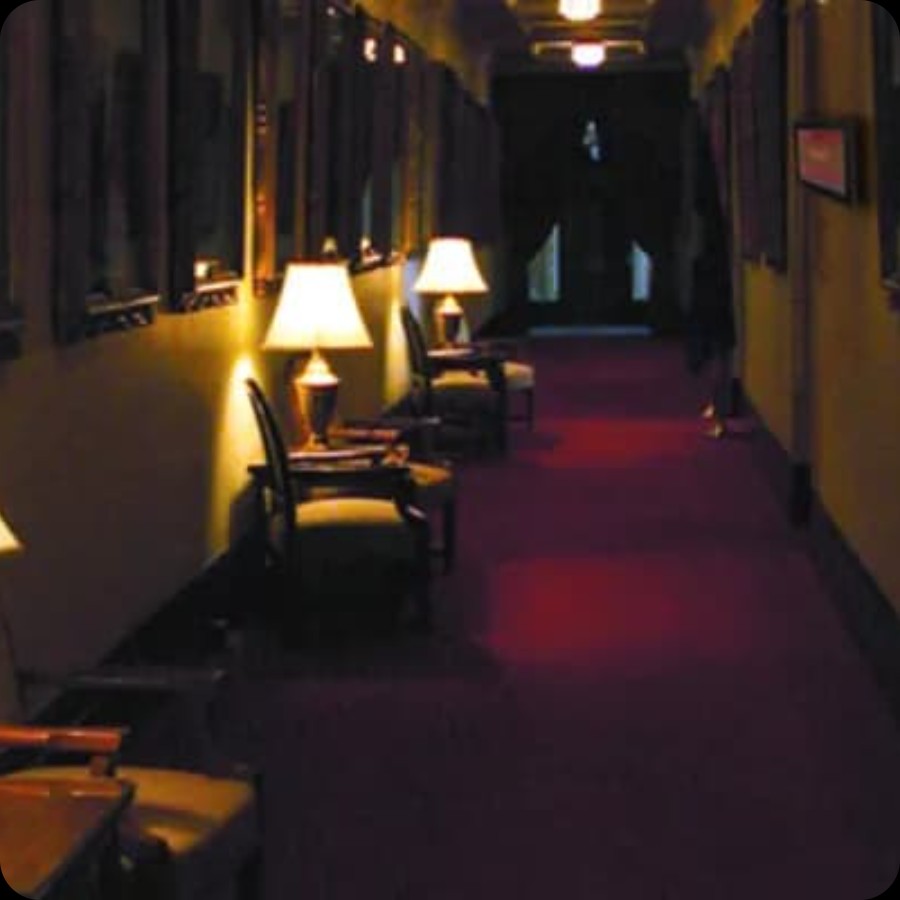Dimly lit hotel conference hallway with room signs suited for IAdea meeting room booking displays