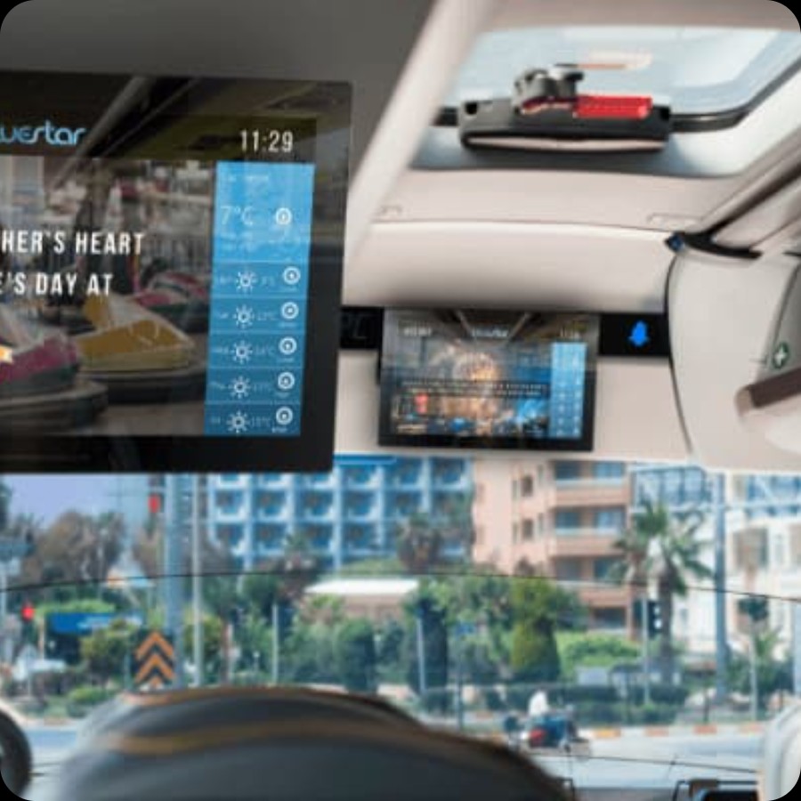 Interior of a ride-sharing vehicle with passenger seat displays for IAdea in-transit advertising