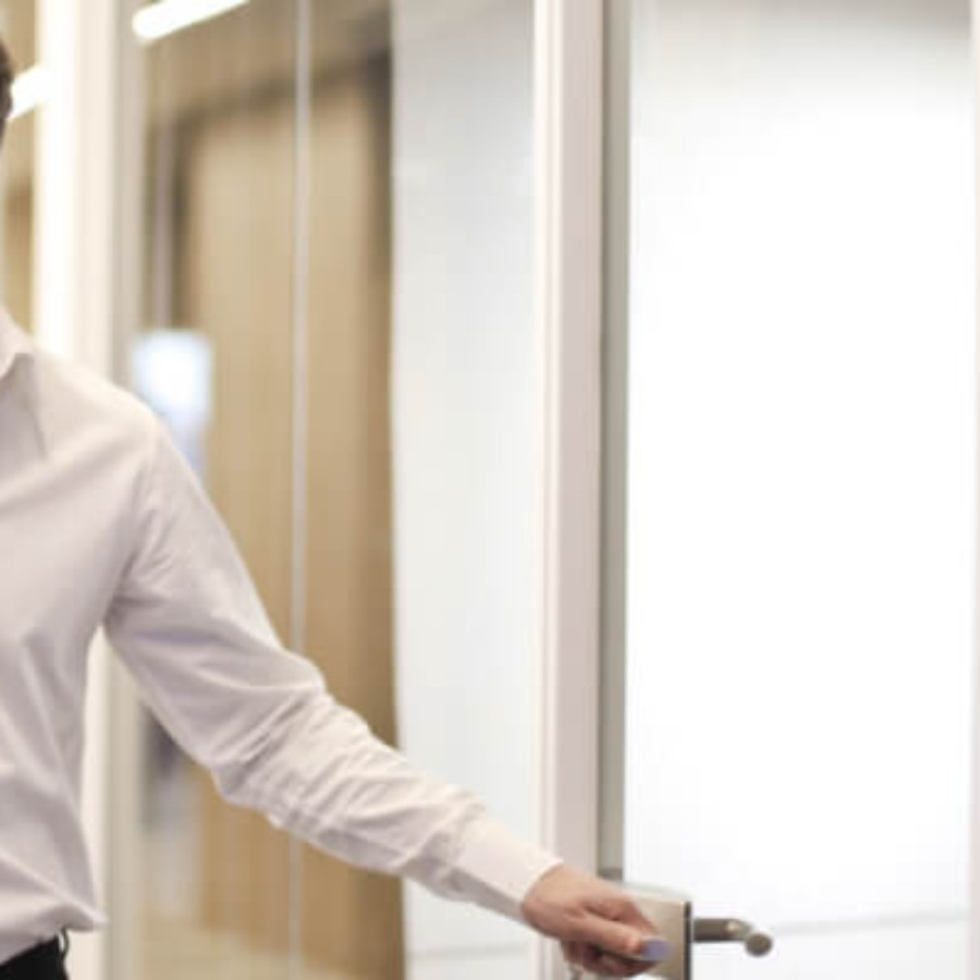 Office worker in a white shirt at a desk in a modern corporate environment with IAdea executive signage
