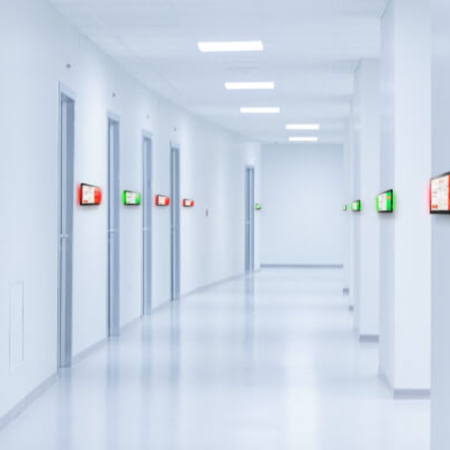 Modern office corridor with glass-walled meeting rooms suited for IAdea room booking displays
